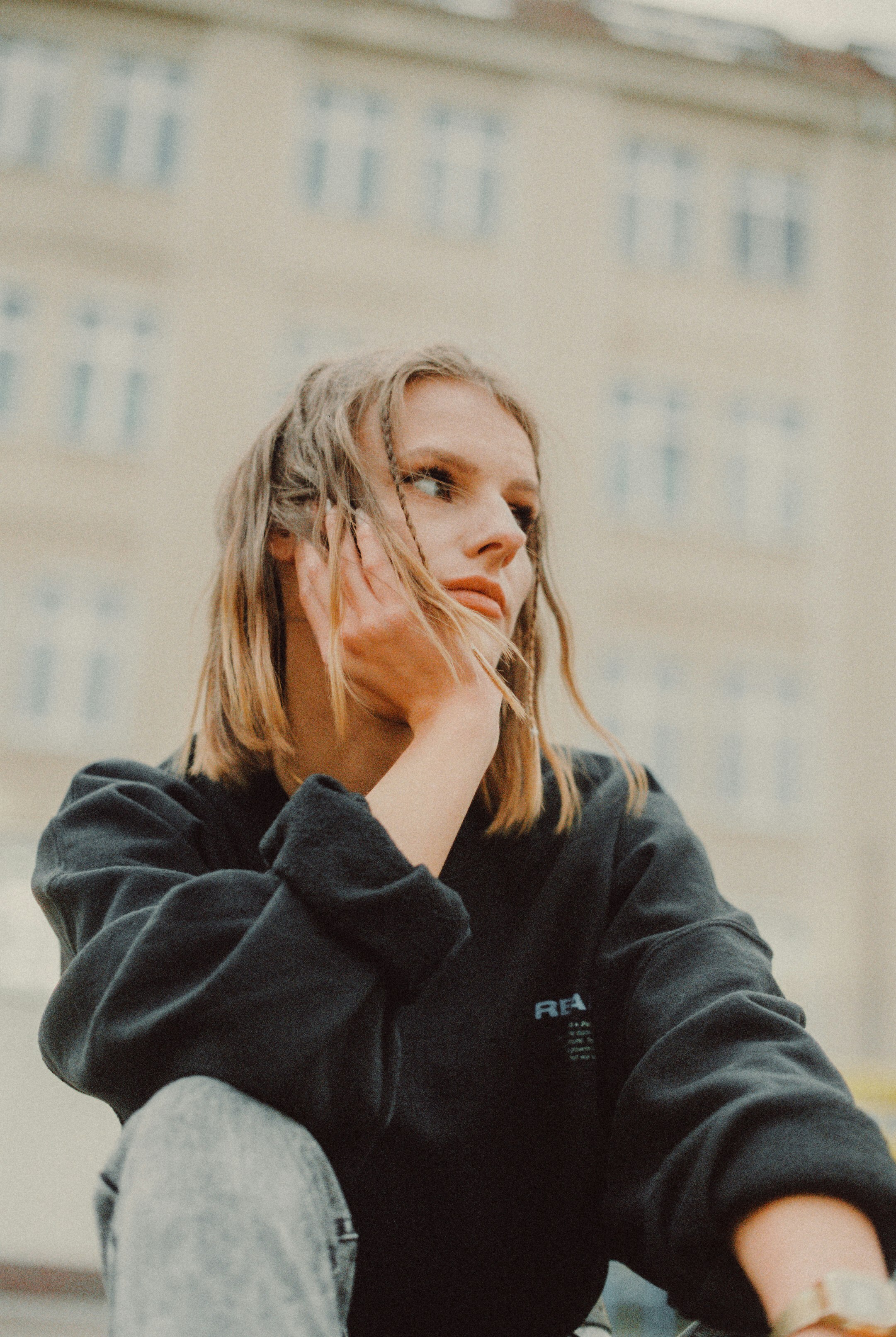 woman in black hoodie covering her face